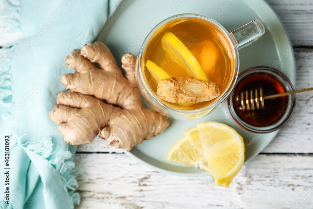 Tray with cup of aromatic tea with lemon, honey and ginger on table
