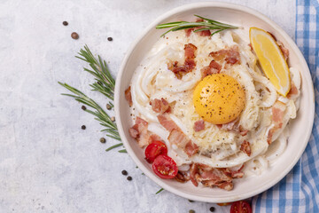 Classic carbonara pasta with fried bacon, parmesan cheese and egg yolk.