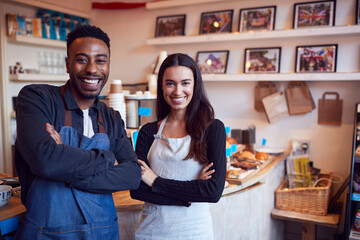 Wall Mural - Portrait Of Smiling Couple Running Coffee Shop Together Standing Behind Counter