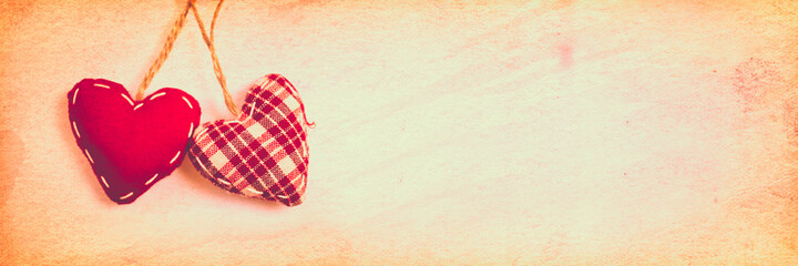 Wall Mural - two red fabric hearts on vintage panoramic background with copy space