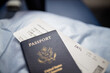 © Christian - American passport and airplane ticket above a seat