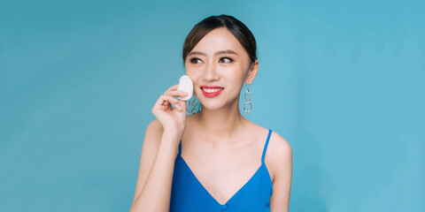 Wall Mural - Attractive Charming Asian young woman smile and using tissue with toner for cleaning make up feeling so fresh and clean with healthy skin