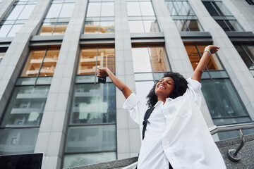 Wall Mural - African american woman in good clothes is outdoors in the city at daytime