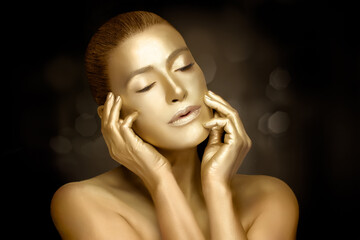 Wall Mural - Gold cosmetics. Female model touching golden skin. 24k gold for skin care treatment