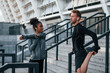 © standret - Doing stretches. European man and african american woman in sportive clothes have workout together