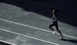 © standret - Fast runner. Young african american woman in sportive clothes have workout outdoors at daytime