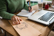 © LIGHTFIELD STUDIOS - cropped view of african american woman touching brochure with menu lettering on table