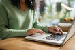 © LIGHTFIELD STUDIOS - cropped view of african american woman using laptop in cafe