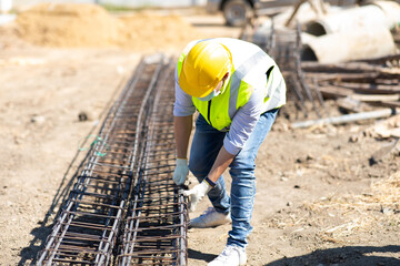 Wall Mural - Asian construction worker on building site. fabricating steel reinforcement bar. wearing surgical face mask during coronavirus and flu outbreak