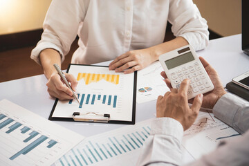 female finance staff is showing her leader a graph of the performance of a rapidly growing real estate company over the past half-year. At her office desk this morning, the finance company profits con