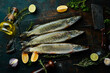 Pike fish with spices and herbs. Preparation. On a dark kitchen background. Top view.