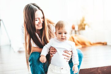 Wall Mural - Mom and baby are sitting on the steps in the room in the sun