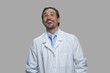 © DenisProduction.com - Man in white coat is laughing on gray background. Happy doctor or scientist is laughing at something hilarious. Positive facial expressions.
