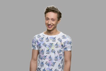 Cheerful teen boy on gray background. Happy smiling teenage boy looking at camera.