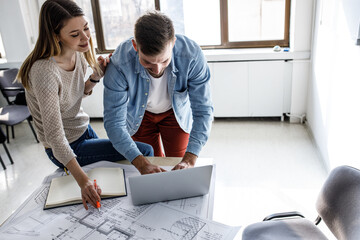 Wall Mural - Two students of architecture examining blueprint in classroom.Educational concept.	
