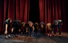 People Bowing To Audience. Group Of Actors In Dark Colored Clothes On Rehearsal In The Theater