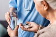 © LIGHTFIELD STUDIOS - partial view of nurse giving pills and glass of water to elderly woman, selective focus