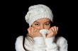 Young attractive woman with white cap, scarf and sweater on black background