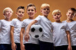 © Roman - confident children soccer team isolated in studio, friendly kids sport family leisure lifestyle concept. professional kids gamers. copy space advertisement