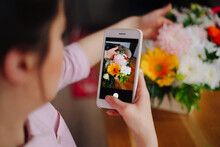 Flower Shop: A Girl Florist Photographs A Flower Composition On A Smartphone For Social Networks.