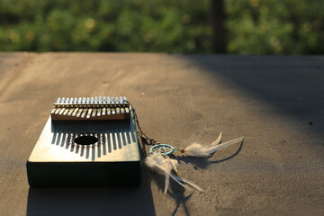 Wall Mural - Kalimba or mbira is an African musical instrument.Traditional small Kalimba made from  wooden board with metal, play on  hands and plucking the tines with the thumbs. Instrument in room