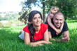 © Вероника Зеленина - happy parents with daughter lies on the green grass.  People having fun on the park. Woman and kid hug the father