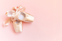 New Pastel Beige Ballet Shoes With Satin Ribbon Isolated On Pink Background. Ballerina Classical Pointe Shoes For Dance Training. Ballet School Concept. Top View Flat Lay, Copy Space