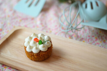 Wall Mural - Homemade cupcake with white cream frosting on wooden tray.