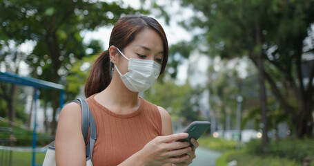 Wall Mural - Woman wear face mask and use of mobile phone