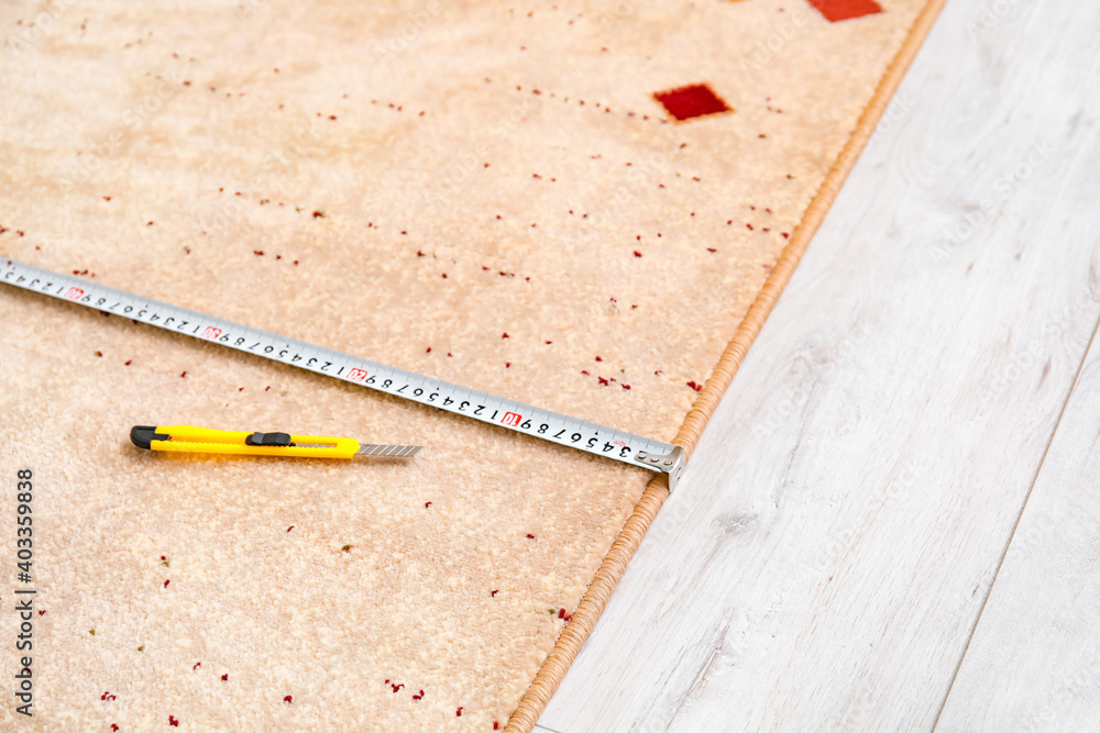 Measuring tape and knife on carpet
