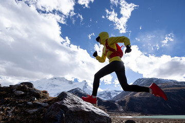 Wall Mural - Woman trail runner cross country running in high altitude winter mountains