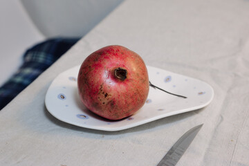 Pomegranate fruit on a plate on the table