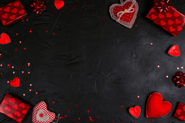 Wall Mural - Frame of red gifts, hearts and candles on black background.