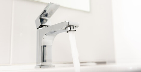 The faucet in the bathroom where the sink is left open has running water.