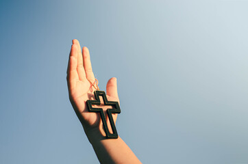 Sticker - Image of young woman hand holding and raising crucifix christian religious symbols in light and scenery religious background faith concept