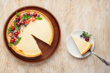 Wall Mural - Cheesecake New York with berries on a plate on a bright background. Top view