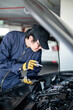 © zephyr_p - Asian auto mechanic holding digital tablet checking car engine under the hood in auto service garage. Mechanical maintenance engineer working in automotive industry. Automobile servicing and repair