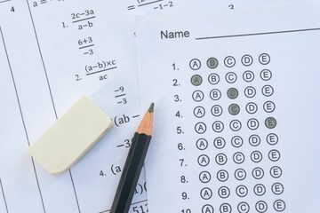 Pencil and eraser on answer sheets or Standardized test form with answers bubbled. multiple choice answer sheet