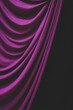 © Mint Images - Detail draped purple curtain against black background