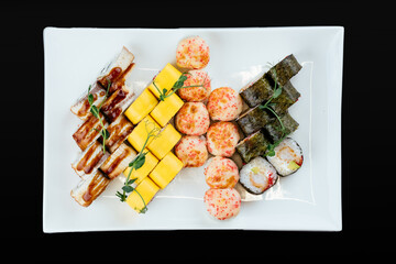 Wall Mural - Japanese sushi sets on a white plate and black background