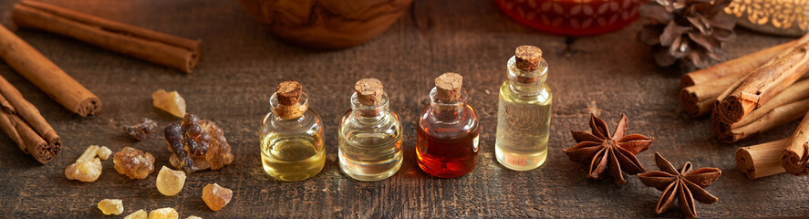 Wall Mural - Panoramic header of essential oil bottle with frankincense resin and Christmas spices - cinnamon and star anise