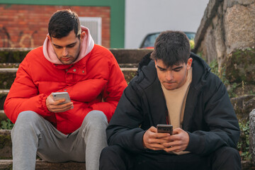 Wall Mural - young people with mobile phone sitting on the stairs