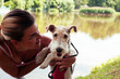 © iordani - pretty woman with cute dog fox terrier playing in green sunny park, lifestyle people concept