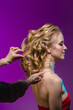 © Miramiska - Stylist makes girl's hair. Combing female hair. Hair care for woman. Stylist makes an evening hairstyle for model at photo shoot.