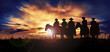 Group of cowboys on horseback at sunset