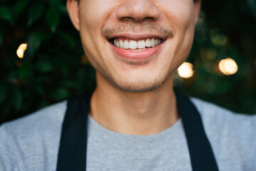 Close up of man with mustache with white teeth.