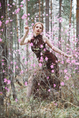 Poster - Japanese-style girl in a flowering forest among pink flowers in spring