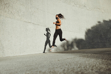 Wall Mural - Athletic woman running wearing protective face mask