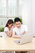 © eastfenceimage - A young Couple Using Laptop at Home