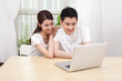 © eastfenceimage - A young Couple Using Laptop at Home